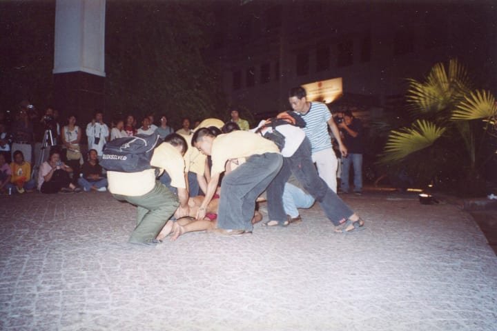 Volunteers carrying artist Lê Vũ and his father from "backstage" to the front yard of British Council.